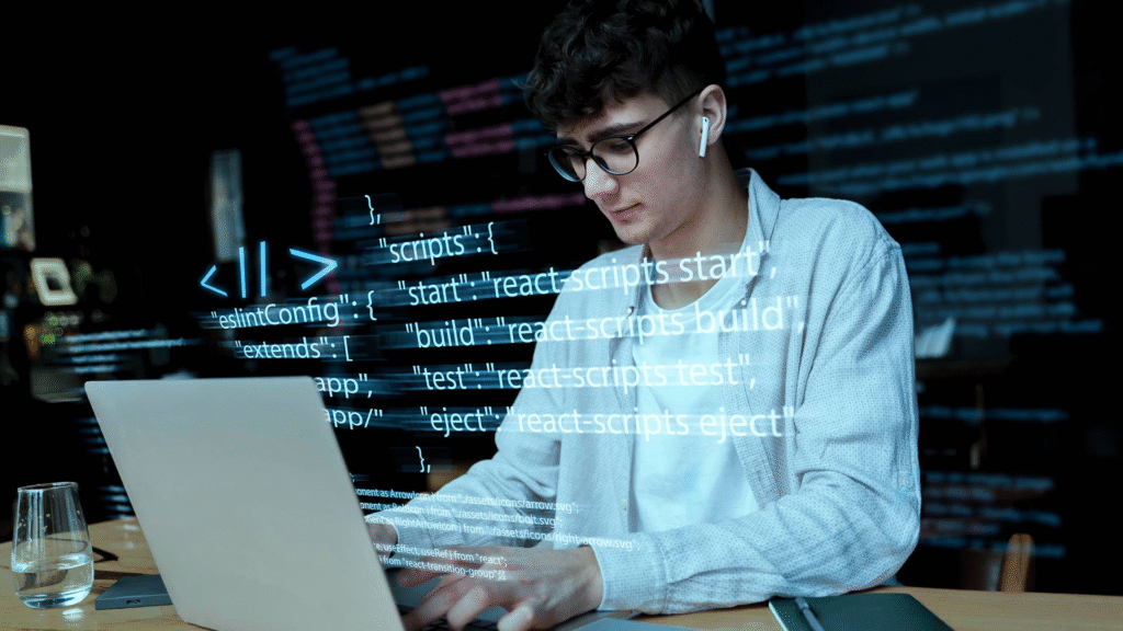 Joven desarrollador escribiendo código en su laptop con visualización de scripts en pantalla, usando tecnologías modernas.